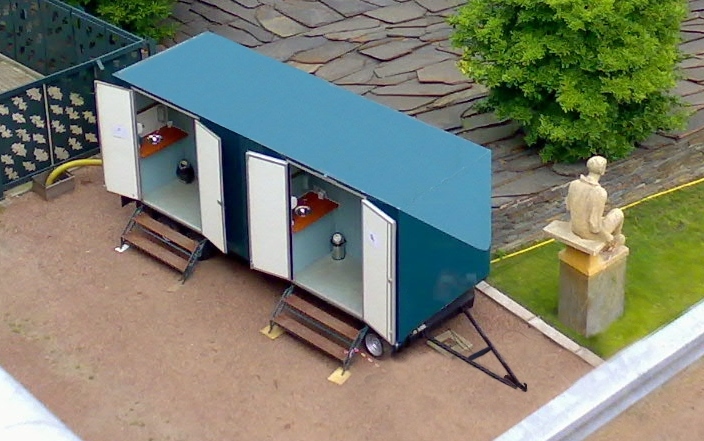 Moderne toiletwagen opgesteld in een tuin